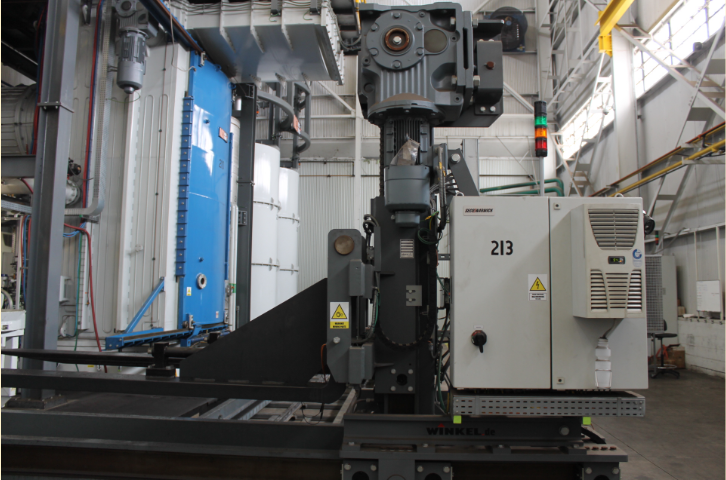 A vertical gantry sits alongside other heat treatment equipment.